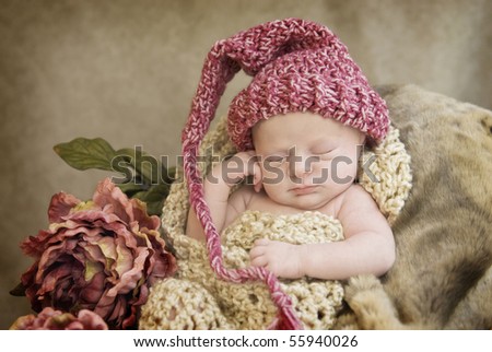 A sleeping newborn baby girl in crocheted  cocoon wearing hat with vintage looking setup, selective focus with focus on face