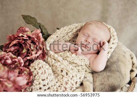 A sleeping baby girl in a basket with blankets and vintage flowers, soft focus with shallow depth of field