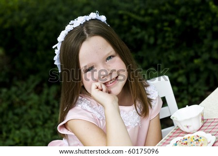 A beautiful little girl having a tea party outside, selective focus, copy space