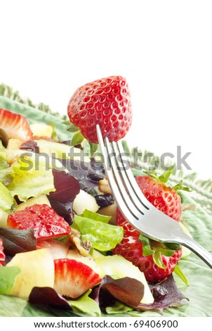 A delicious low fat fruit salad with fresh strawberries, apples and cranberries, covered in Raspberry Vinaigrette Dressing, selective focus