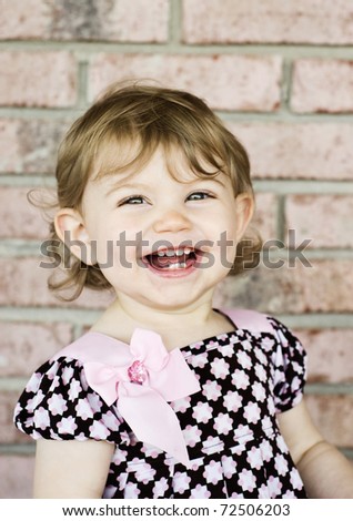 Adorable little girl with a big smile, vertical with selective focus on face and copy space