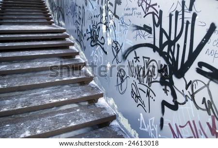 Ice covered wooden stairs beside graffiti wall