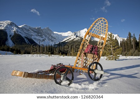 vintage snowshoe gear in the snow with mountains in the background