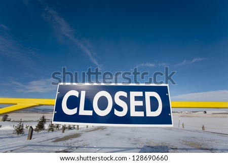 winter road closure sign on barrier