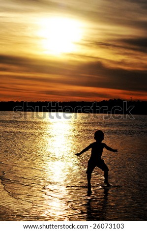 Boy jumping in river at sunset