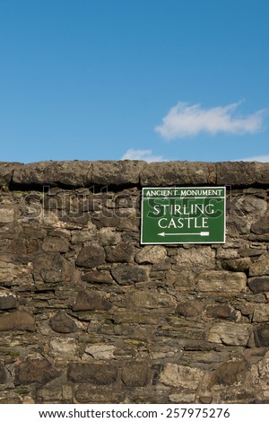 Stirling Old Town, Scotland, UK - green metal sign pointing towards Stirling Castle on old stone wall