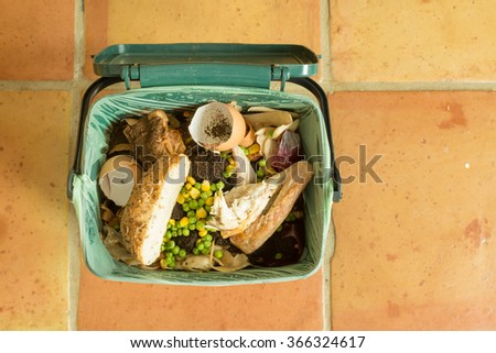 Indoor food recycling caddy full of kitchen waste including meat and bread (which can\'t be composted at home) to be collected as part of a local food waste recycling service