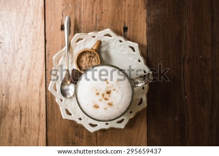 Hot cappuccino set with little sugar,spoon and piece of brownie. Hot coffee on old wood table.Hot coffee vintage decoration.Still life coffee.Hipster and slow life concept.