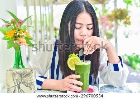 Beautiful woman enjoy healthy.drinking mixed vegetable and fruit juice in vintage cafe.