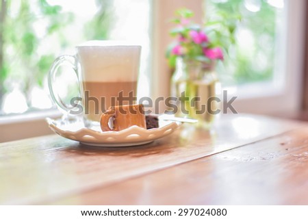 Hot cappuccino set with little sugar,spoon and piece of brownie. Hot coffee on old wood table.Hot coffee vintage decoration.Still life coffee.Hipster and slow life concept.