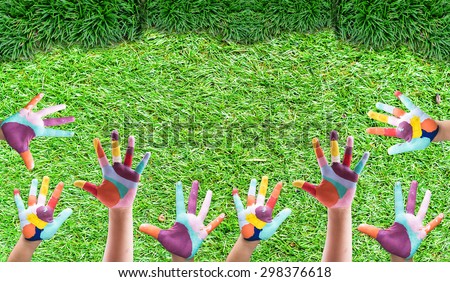 Hand Painted Child.rise up your kids hand on green grass background.