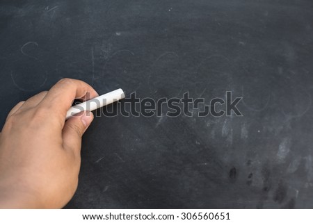 Blank blackboard / chalkboard, hand writing on black chalk board holding chalk, great texture for text.