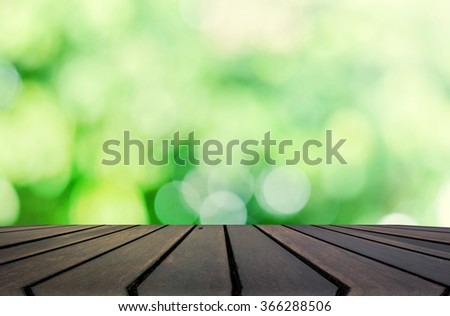 Wood table top on blur green abstract background - can be used for montage or display your products