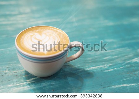 coffee cup and coffee beans.Coffee cup and coffee beans on a wooden table and sack background,Vintage color tone