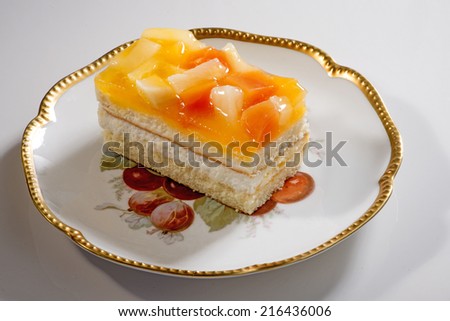 Biscuit  cream layered  cake which fruits in gold lip plate