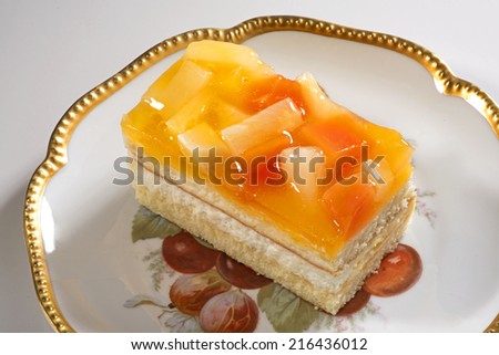 Biscuit  cream layered  cake which fruits in gold lip plate