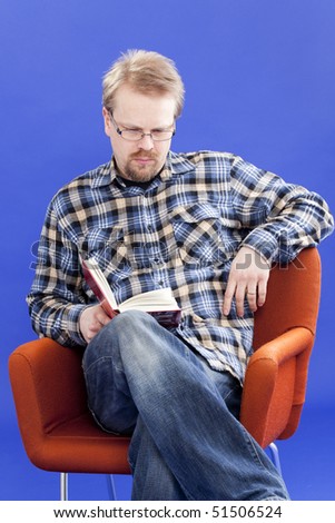 Man reads book in chair.