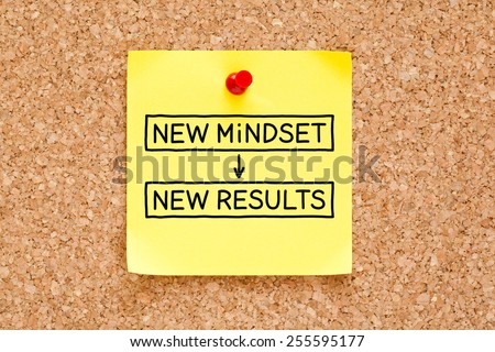 New Mindset New Results written on a yellow sticky note pinned on a bulletin board.