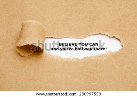 The text Believe you can and you\'re halfway there, appearing behind torn brown paper. Motivational quote.