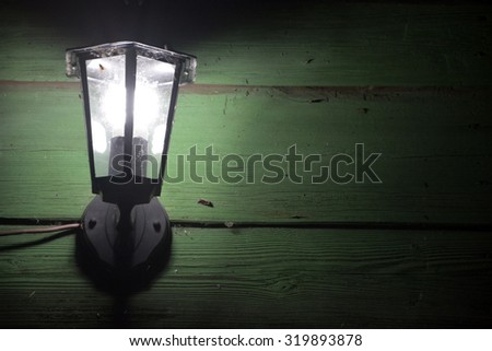 Old vintage lantern on the green wall at the night