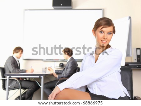 Portrait of business woman with team mates discussing in the background
