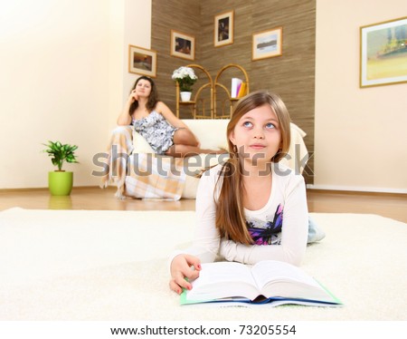 The girl-teenager dreams, reading the book on a floor