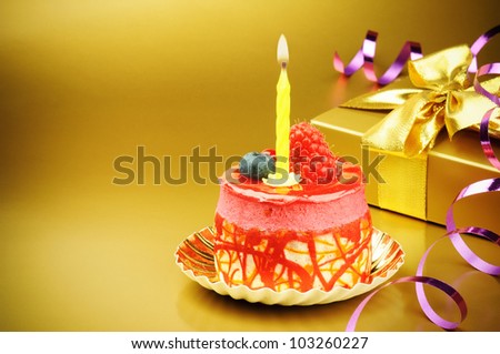 Colorful birthday cake with candle on golden background