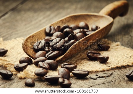 Coffee beans in an old wooden scoop