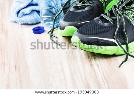 Pair of sport shoes and water bottle. After workout setting