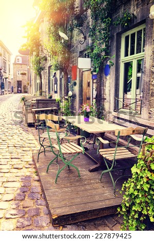 Cafe terrace in small European city at sunny summer day