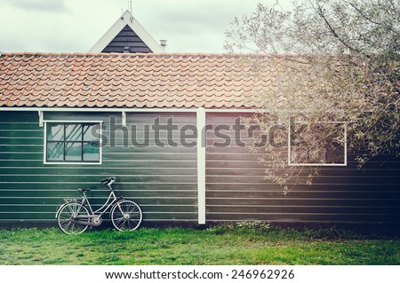 Old bicycle leaning against wooden barn in Holland country