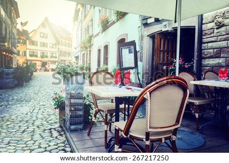 Cafe terrace in small European city at sunny summer day