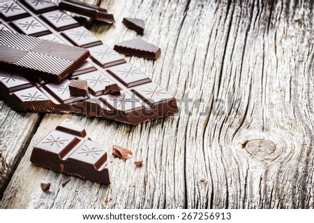 Dark chocolate tablets on old wood background with copyspace