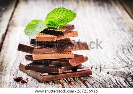 Stack of dark and milk chocolate pieces with mint leaf