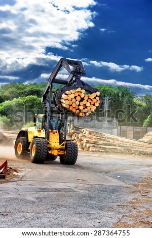 Forklift truck hauling logs at sawmill
