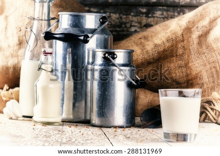 Farm setting with fresh milk in various bottles and cans