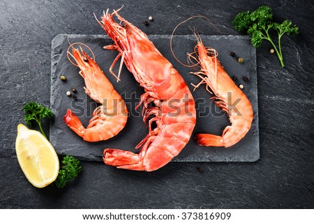 Fine selection of jumbo shrimps for dinner on stone plate. Food background