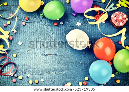 Colorful birthday frame with multicolor party items on dark blue background. Happy birthday concept with copy space
