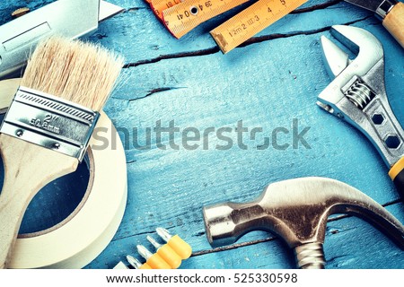 Set of various tools on blue wooden background. Construction and renovation concept with copy space