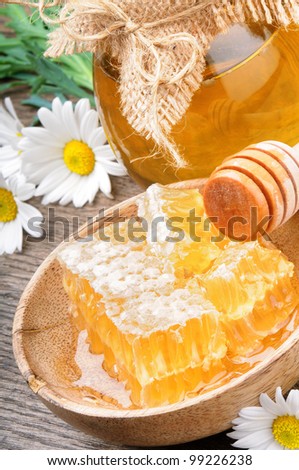Glass honey pot and comb with daisies