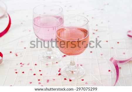 Red and pink fizzy drinks against a Valentine\'s Day themed backdrop with mini hearts