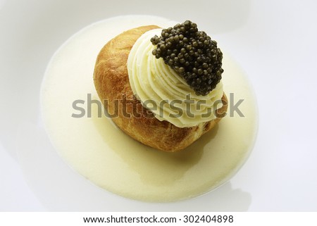 Appetizer potato covered with puff pastry, white Sparkling Wine Mousse and Caviar