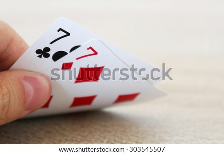 Poker game with hand of two lucky sevens