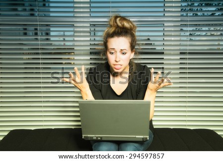 Young Woman talking on line with laptop in apartment very animated