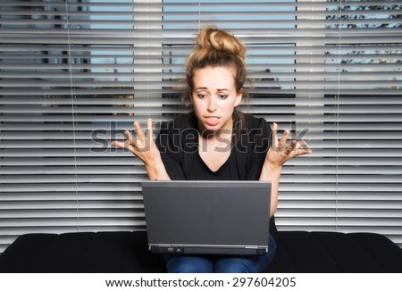 Creative young woman in apartment with laptop very animated