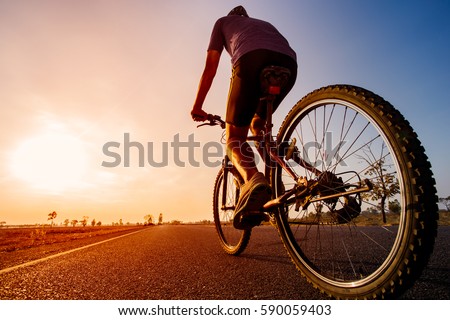 Asian men are cycling road bike in the the sunset