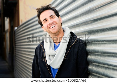 Portrait of handsome happy man in urban background