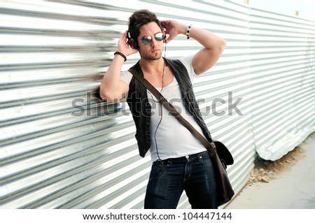 Portrait of young happy man in urban background