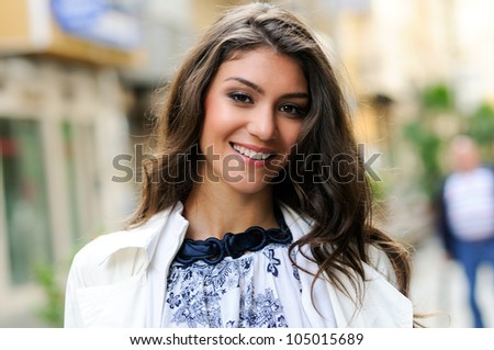 Portrait of a beautiful young woman smiling in urban background