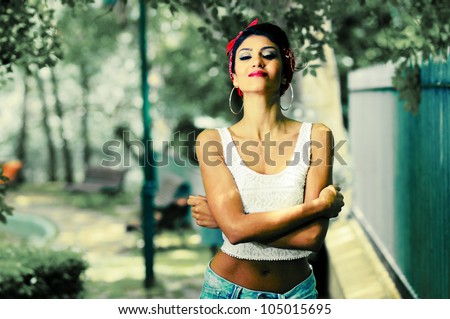 Portrait of a pin-up girl in a garden wearing jeans and t-shirt